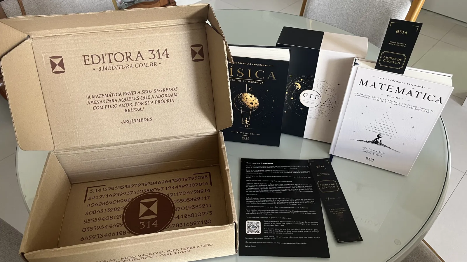Caixa da Editora 314 aberta com o Guia de Fórmulas Explicadas de Física e de Matemática, o box e os marcadores