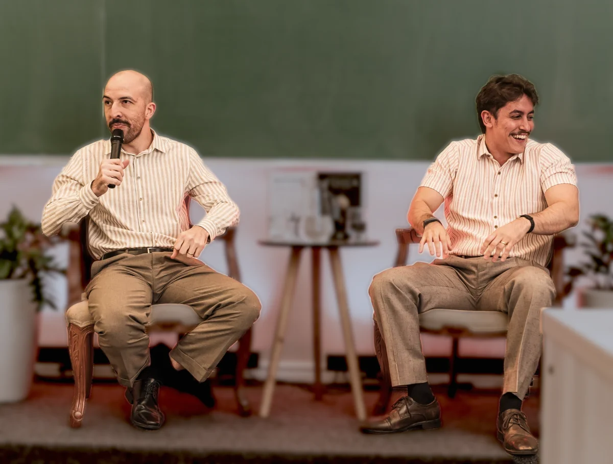 Os dois autores no bate-papo do lançamento, com os livros na mesa